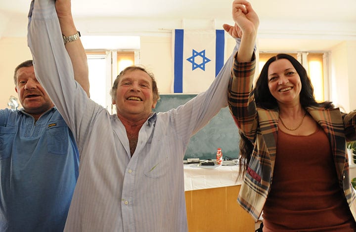 Israeli dancing with Israeli flag in background