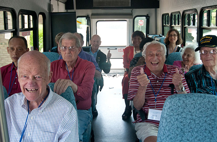 senior citizens cheering on bus