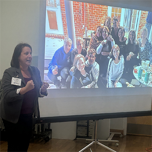 NOVA Leadership Cohort 2025 NOVA leadership cohort presenter in front of projector showing group photo of NOVA organization