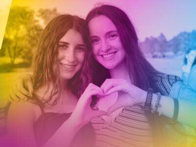 Two teen girls holding a heart with their hands