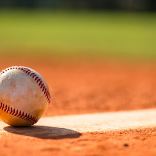 Baseball with dirt on it sitting atop pitchers mound close up
