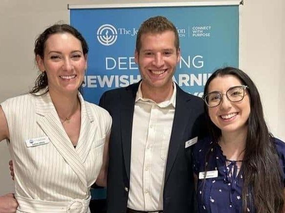 Three Federation staff members smiling together at an event