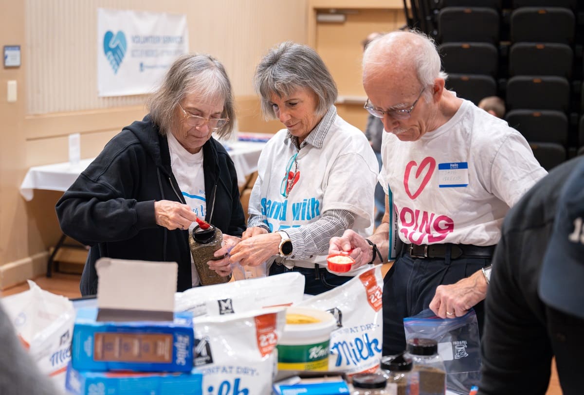 Three people volunteering and preparing food