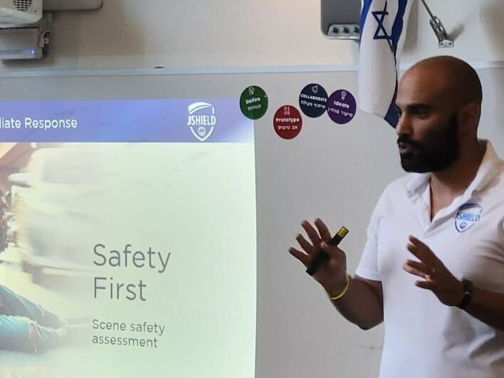 Presenter standing in front of a screen displaying 