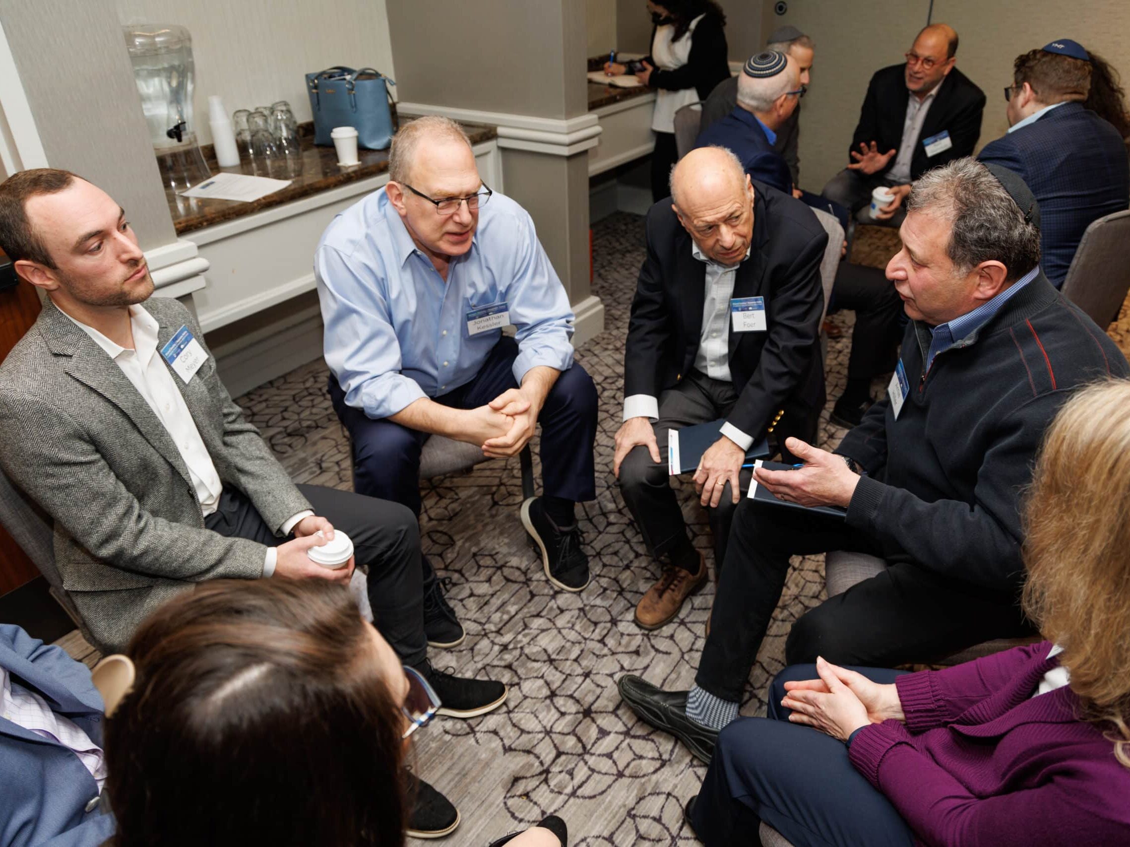 A group sit in a circle and converse at a Shalom Hartman event
