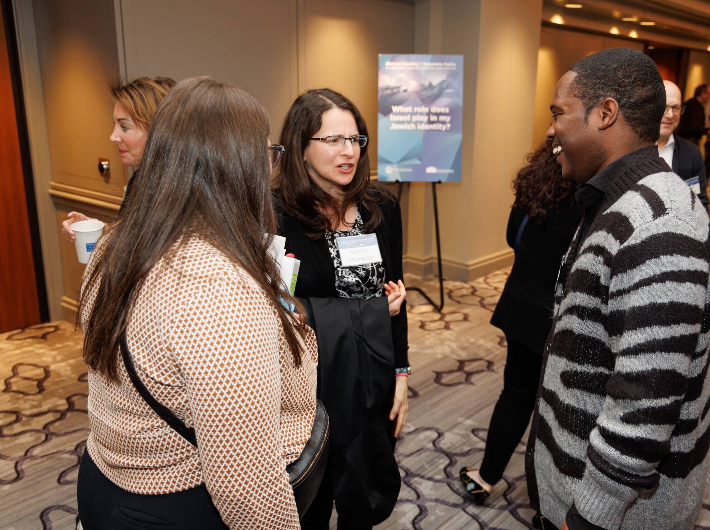 Group of people talking at a Shalom Hartman event.
