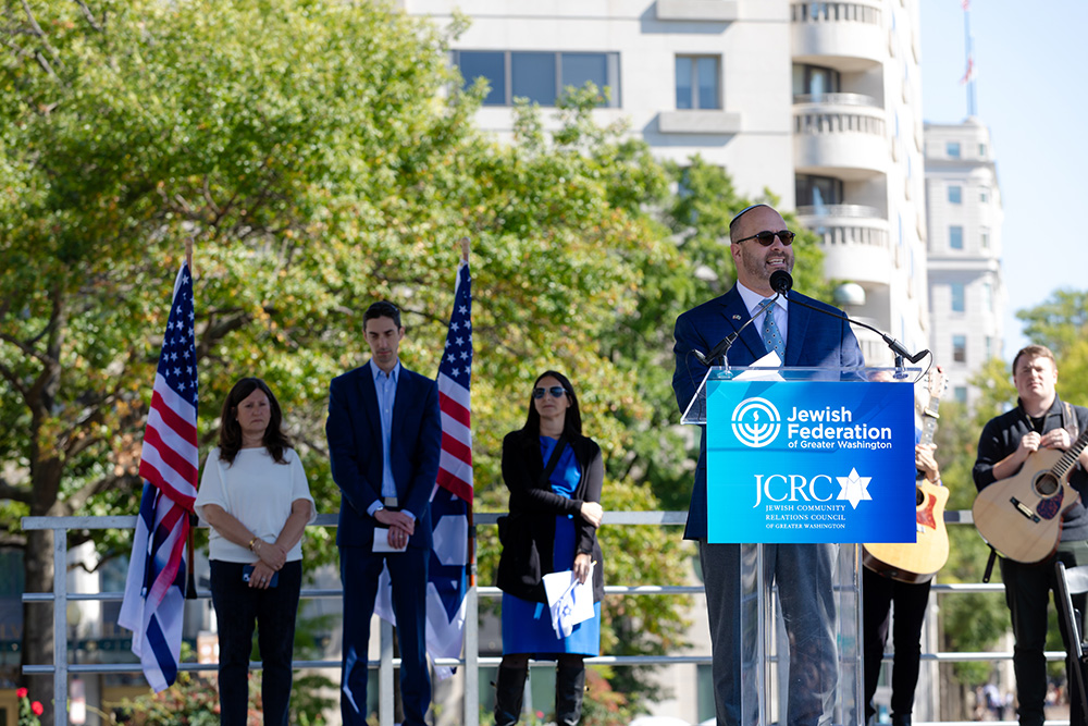 Man at podium with Federation and JCRC sign speaking in Washington, DC.