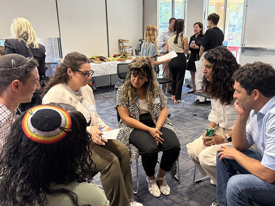 A group of people sit in chairs in a circle