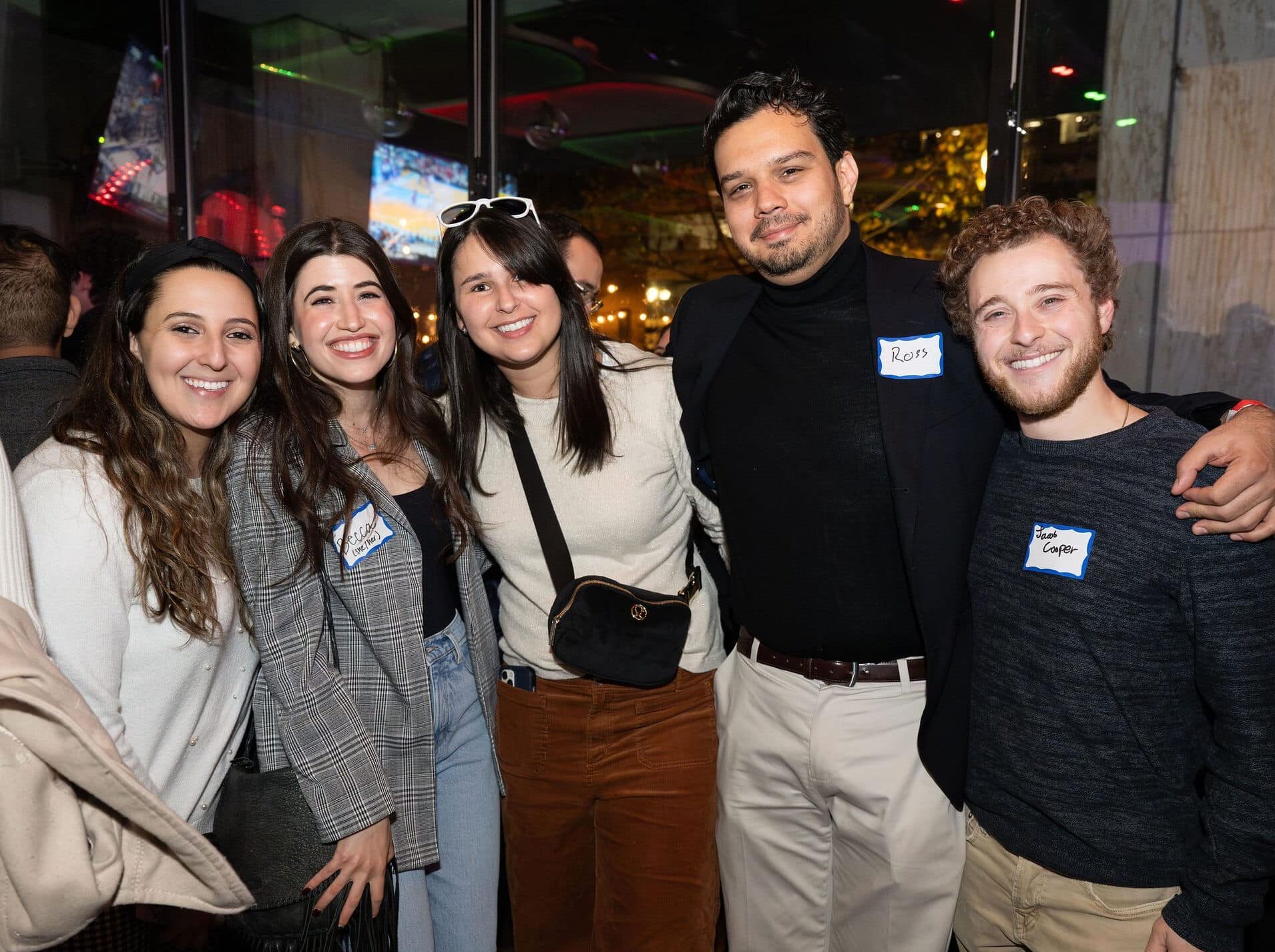 Group of people standing, smiling.