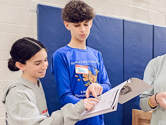 Students looking at directions on how to build a house.