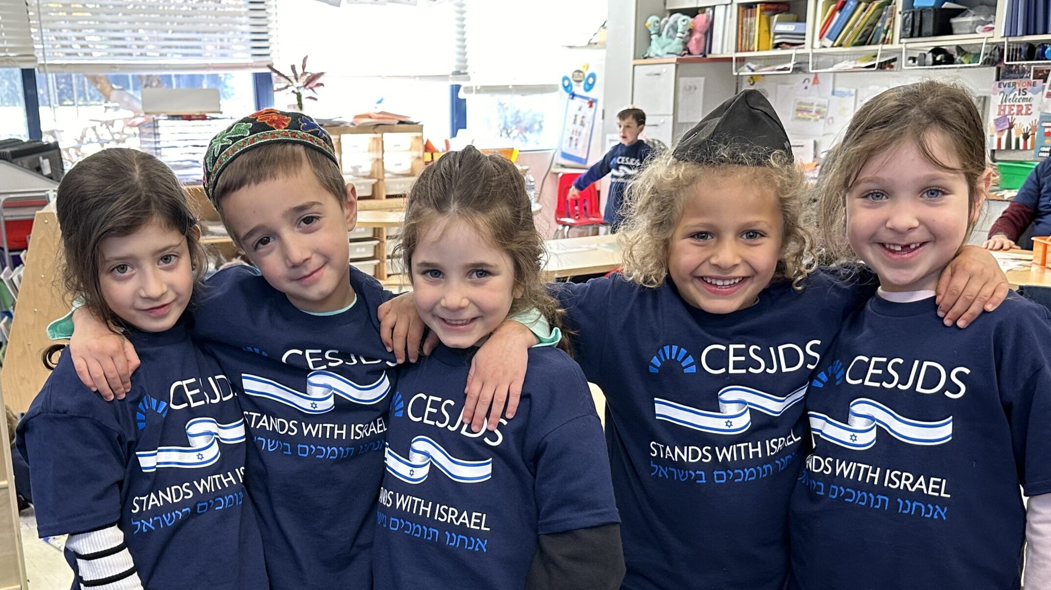 Children at Charles E. Smith Jewish Day school stand together, wearing matching shirts.