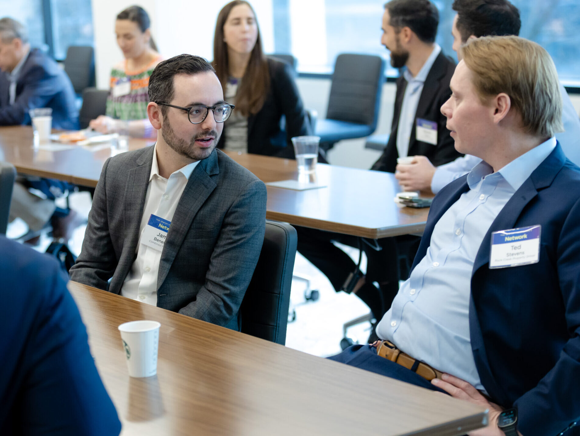 Group of people sitting at table speaking to one another, at the Network Northern Virginia Alliance Breakfast